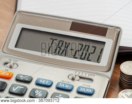 Tax Word And 2021 Number On Calculator. Business And Tax Concept. Pay Tax In 2021 Years.