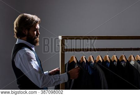 Tailor, Tailoring. Stylish Mens Suit. Male Suits Hanging In A Row. Men Clothing, Boutiques. Man Suit
