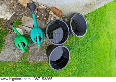 Buckets And Watering Cans Filled With Rainwater