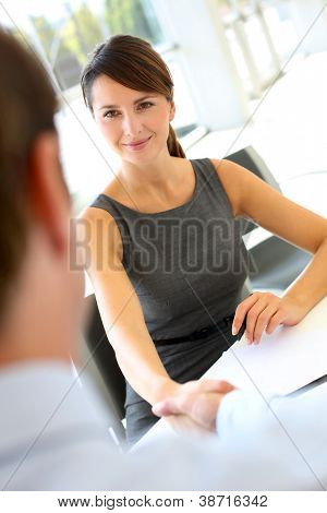 Entrevistador, agitando a mão ao futuro empregado