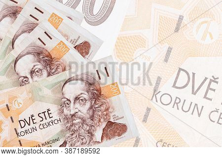 200 Czech Korun Bills Lies In Stack On Background Of Big Semi-transparent Banknote. Abstract Busines