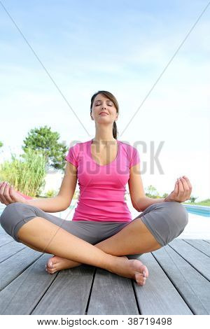 Brunette meisje doen yoga oefeningen bij zwembad