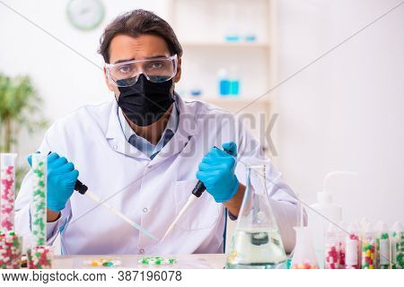 Young male chemist in drug synthesis concept