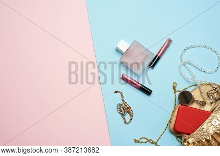 Golden Handbag, Lip Gloss And Beads On A Blue Background, Top View, Copy Spave