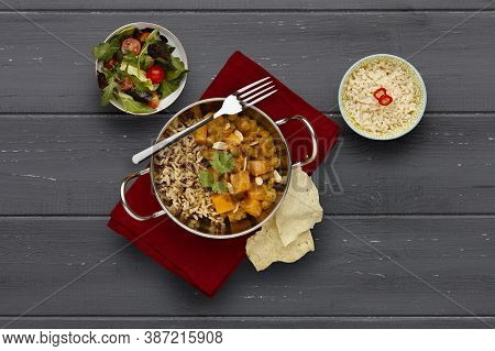 A Traditional Blati Dish Filled With Delicious Vegetable Curry And Rustic Rice, Garnished With A Spr