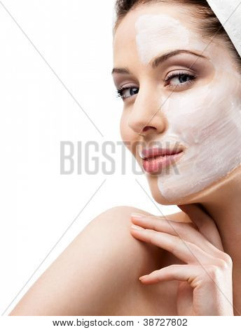 Mujer en diadema con elevación crema aplicada en una mitad del rostro, aislado en blanco
