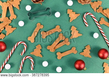 Homemade Baked Dog Treat Cookies In Shape Of Bones And Christmas Tree On Festive Green Background De