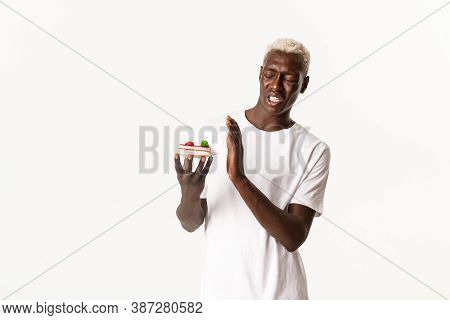 Portrait Of Disgusted Handsome African American Young Blond Man, Unwilling Eat Dessert, Cringe From 