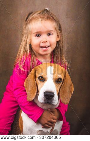 2 Yeras Old Child Hugging Best Friend Dog. Happy Childhood With Pet Beagle. Dog Background