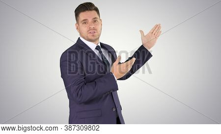 Smiling Businessman Pointing On Something And Talknig On Gradien