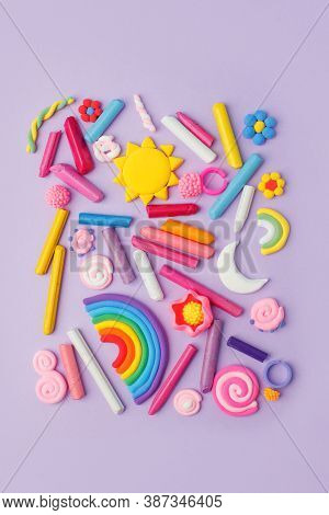 Abstract Purple Pastel Background With Many Kids Accessories From Clay, Wax Chalk, Concept Of Pop Ar
