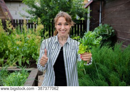 Attractive Smiling Young Brunette Woman Holds Bouquet Of Green Onions, Parsley And Salad Leaves Thum