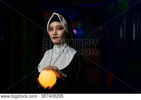 Scary Woman Devil Nun Holding A Cross. Horror Halloween Concept