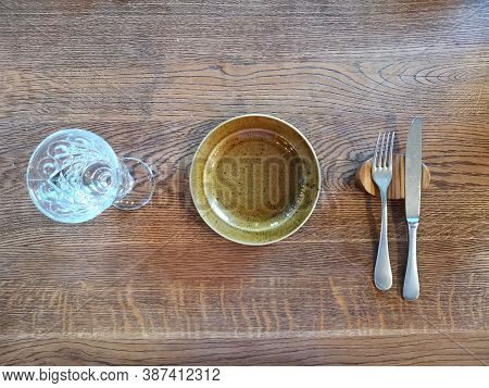 An Empty Plate And A Glass Of Water On A Wooden Table. Waiting For Lunch Or Dinner
