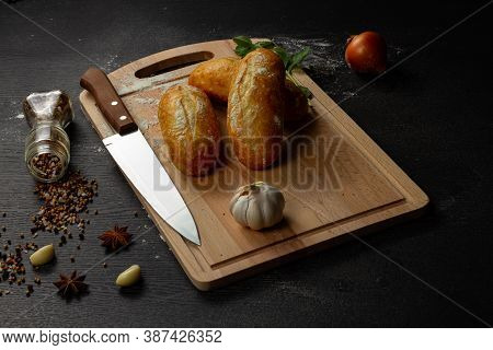 Fresh Wheat White Bread On A Cutting Board With Seasonings Sprinkled With Flour On A Black Wooden Ta
