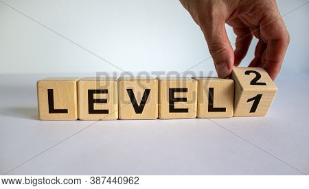 Time For Level 2. Hand Is Turning A Cube And Changes The Word 'level 1' To 'level 2'. Beautiful Whit