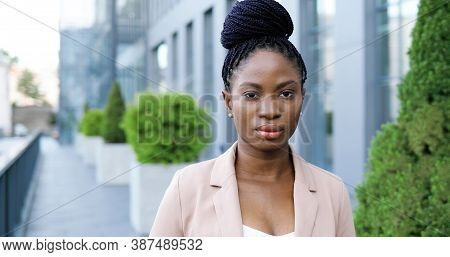 Portrait Of Young African American Beautiful Woman Looking To Camera With Serious Face Outdoor. Clos