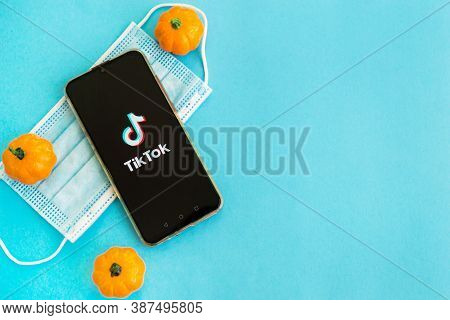 Tver, Russia - September 25, 2020, Medical Mask, Pumpkins And Tik Tok Logo On The Smartphone Screen 