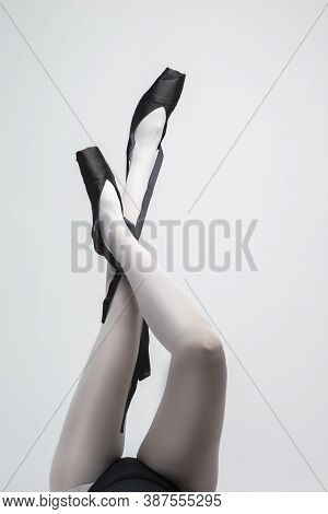 Ballet Dancer Legs In Laced Pointes Shoes. Posing With Lifted Crossed Legs.