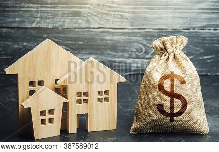 Dollar Money Bag And Figurines Of Residential Buildings. Financing Urban Development And Infrastruct