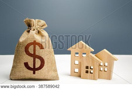 Dollar Money Bag And Figurines Of Residential Buildings. Mortgage Loan. City Municipal Budget. Inves