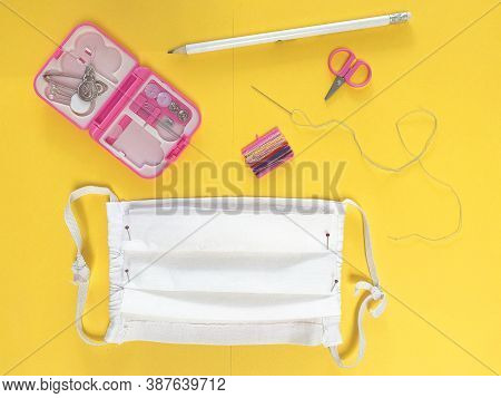 Close Up. Making Of Medical Face Mask At Home With Pink Sewing Kit On Bright Yellow Background.