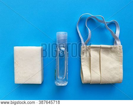 White Hand Soap And Surgical Face Mask And Disinfectant Gel On A Blue Backround