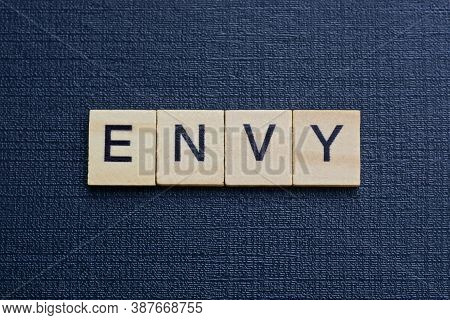 Gray Word Envy From Small Wooden Letters On A Black Table