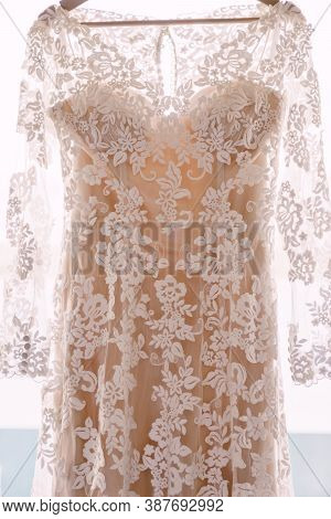 Bridesmaid Dress With Flower Patterns And Beige Lining On A Hanger.
