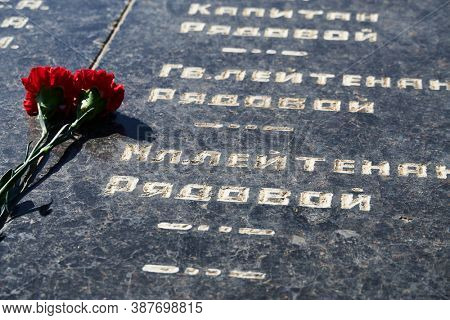 Russian text - sergeant,major, colonel,lieutenant, ranker - army ranks, flowers on the memorial to fallen soldiers, red carnations on black marble