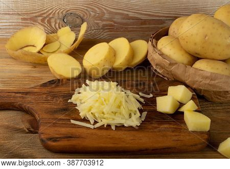 Raw Grated Potato On Wooden Cutting Board Background