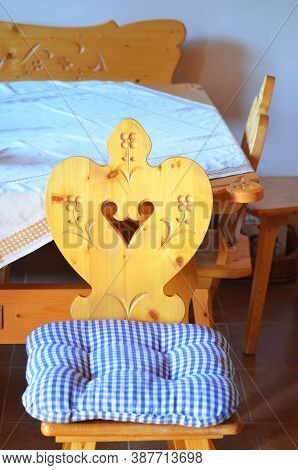 Carved Wood Traditional Chair With Checked Blue Cushion. Same Style Table And Bench In The Backgroun