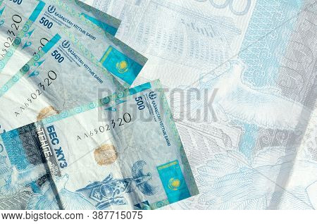 500 Kazakhstani Tenge Bills Lies In Stack On Background Of Big Semi-transparent Banknote. Abstract B