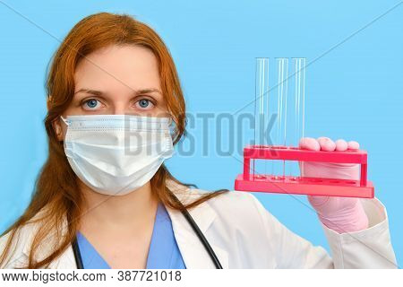 Woman Doctor Holding Test Tubes On A Blue Background, Close-up.