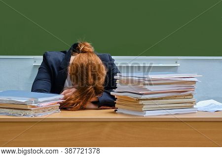 Woman Teacher Sleeps Resting Her Head At School Desk, Copy Space. Tired School Teacher Due To Overwo