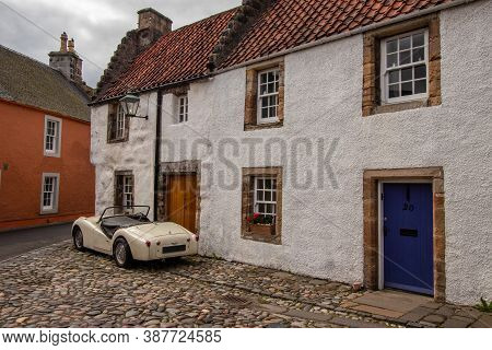 Culross, Fife / Uk - 08/28: Classic Car Parked On Cobbles Beside Old Traditional Whitewashed Scottis