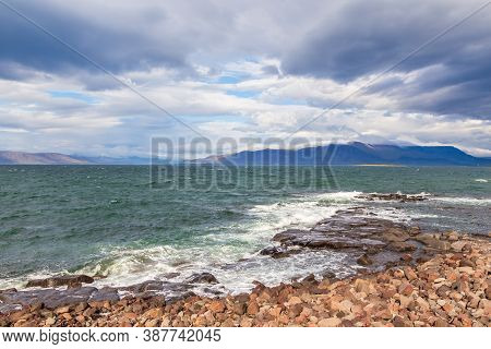 Rocky Coast Of Faxafloi Bay, Mountain In The Background. Seltjarnarnes, Reykjavik, Iceland.