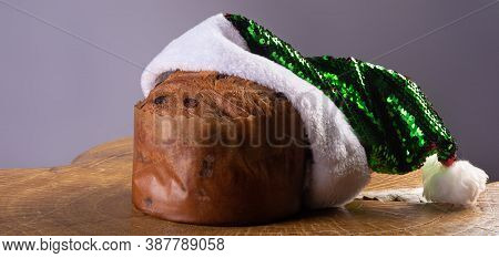 Panettone With Chocolate Chips And Santa Claus Hat On Rustic Wood With Gray Background, Selective Fo