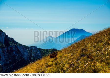The Peaks Of The Alps Around Lake Garda Surrounded By Fog With Blue Sky Seen From Monte Altissimo, T