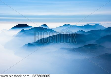 The Peaks Of The Alps Around Lake Garda Surrounded By Fog With Blue Sky Seen From Monte Altissimo, T