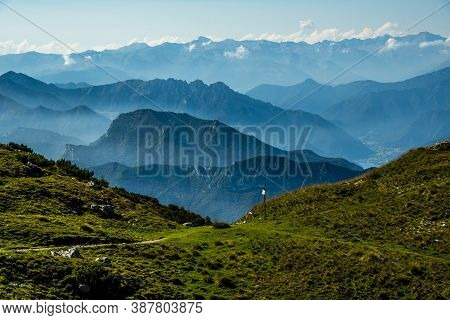 The Peaks Of The Alps Around Lake Garda Surrounded By Fog With Blue Sky Seen From Monte Altissimo, T