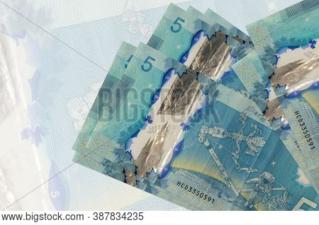 5 Canadian Dollars Bills Lies In Stack On Background Of Big Semi-transparent Banknote. Abstract Pres