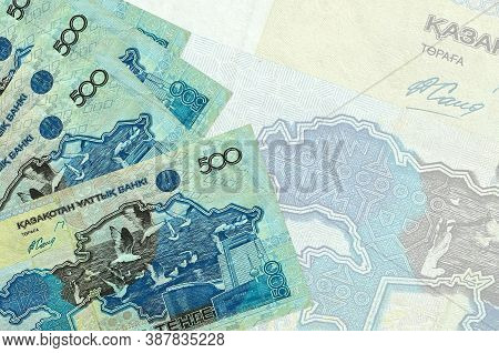 500 Kazakhstani Tenge Bills Lies In Stack On Background Of Big Semi-transparent Banknote. Abstract B