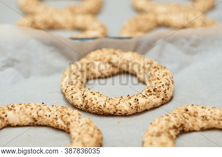 Simit Prepared For Baking On A Baking Sheet - A Bun With Sesame Seeds Close-up (turkish Bagel - Gevr