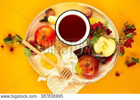 Cozy Autumn Hot Tea With Honey, Apples And Red Hawthorn Berries On A Tray. Still Life On An Orange B