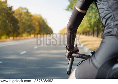 Hands Of A Cyclist Resting On Road Bike Handlebars, Road View With Copy Space. Cycling, Bicycle Spor