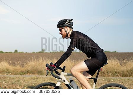 Man Rides A Gravel Bike Outdoors. Well Equipped Cyclist On A Modern Bicycle Outdoors