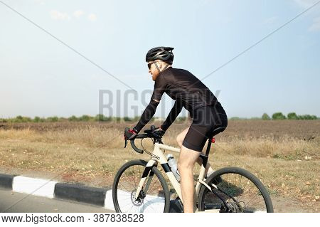 Man Rides A Gravel Bike Outdoors. Well Equipped Cyclist On A Modern Bicycle Outdoors