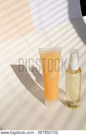 Spray Bottle Of Hair Conditioner And Natural Cream For Face In Light Background With Copy Space.
