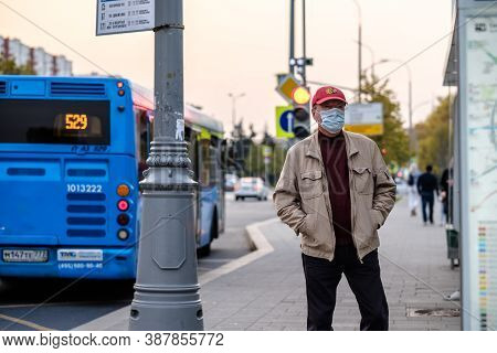 Moscow. Russia. September 25, 2020. A Man In A Medical Mask Stands On The Sidewalk During The Day, W